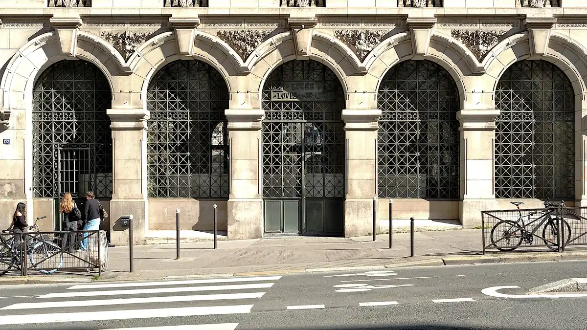 L'entrée du lycée Louis-le-Grand au 123 rue Saint-Jacques : cinq arcades de pierre fermées par des grilles à motifs, la porte verte au centre, un passage piéton et des vélos devant.