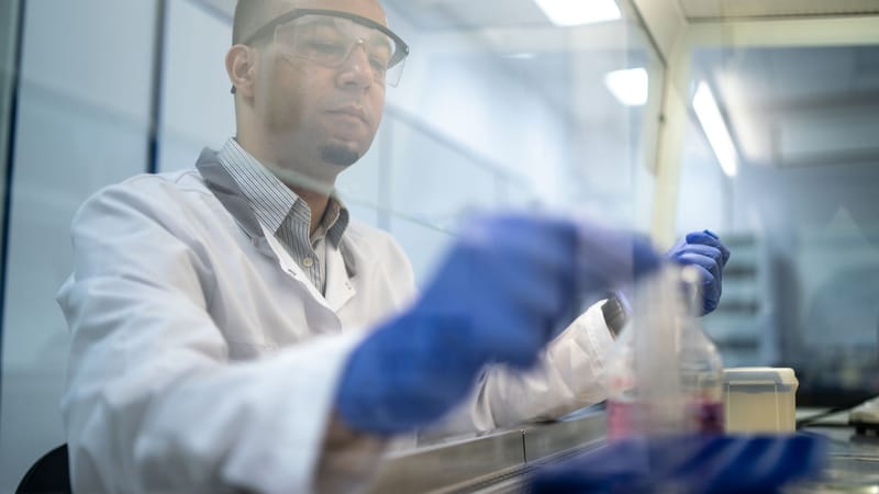 Un scientifique effectue des recherches dans un laboratoire en utilisant des équipements de protection.
