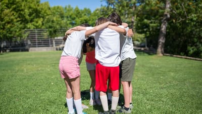 Groupe d'enfants rassemblés à l'extérieur s'engageant dans des activités de cohésion d'équipe.