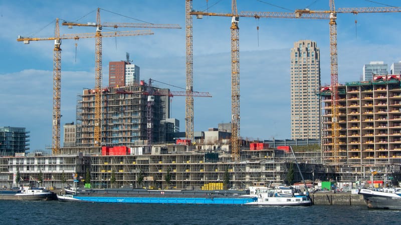 Un chantier de construction moderne avec plusieurs grues et bâtiments en cours de construction.