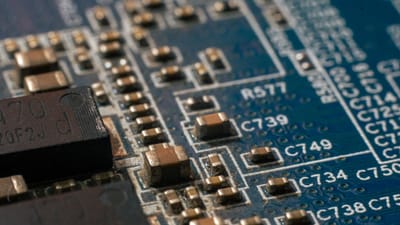 Photo macro détaillée d'une carte de circuit mettant en évidence les composants électroniques et les pistes.