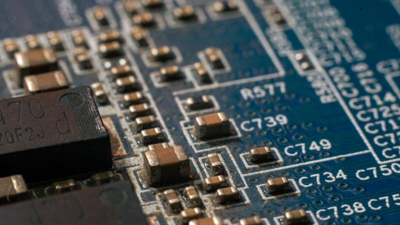Photo macro détaillée d'une carte de circuit mettant en évidence les composants électroniques et les pistes.