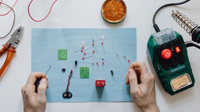 Réparation électronique pratique avec des outils, une carte de circuit et une station de soudage sur l'espace de travail.