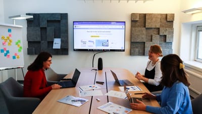 Une équipe de femmes collaborant lors d'une réunion d'affaires avec des ordinateurs portables et des présentations.