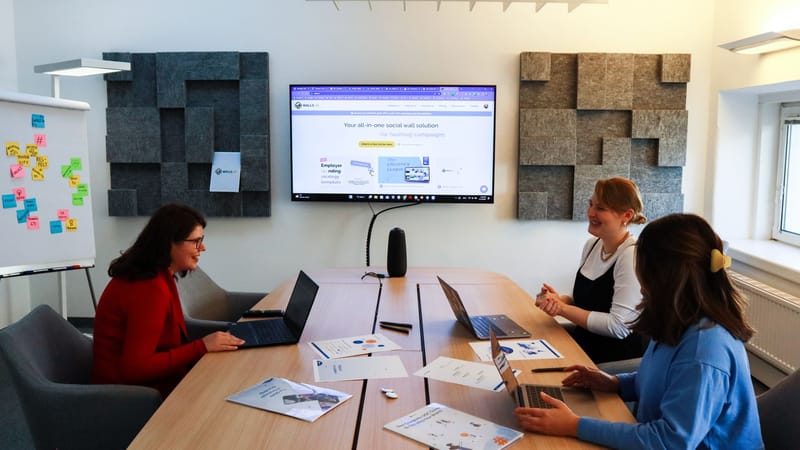 Une équipe de femmes collaborant lors d'une réunion d'affaires avec des ordinateurs portables et des présentations.