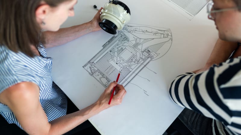 Deux ingénieurs collaborent sur un plan technique détaillé, axé sur l'innovation et la planification.