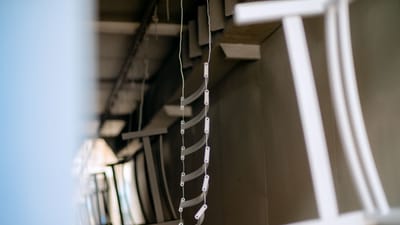 Gros plan de pièces métalliques industrielles suspendues dans un processus de revêtement, mettant en valeur les détails de fabrication.