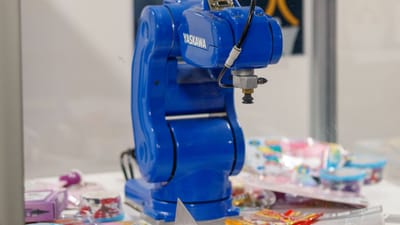 Un bras robotique industriel bleu Yaskawa exposé, présentant une technologie et une robotique de pointe.