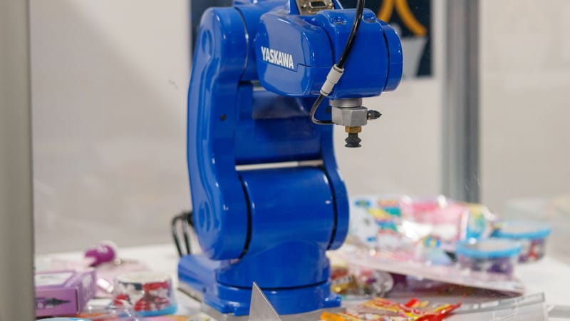 Un bras robotique industriel bleu Yaskawa exposé, présentant une technologie et une robotique de pointe.