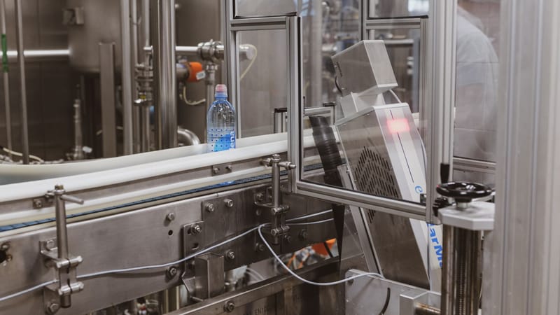Gros plan sur une bouteille en plastique dans une ligne de production d'embouteillage moderne.