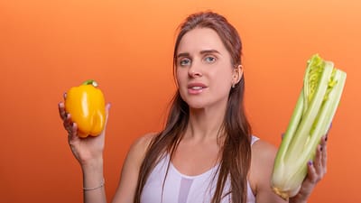 Femme tenant un poivron jaune et du céleri, mettant en avant une alimentation saine.