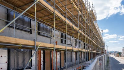 Échafaudages sur un site de construction en ville sous un ciel bleu dégagé.