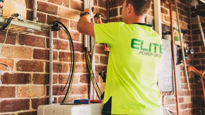 Électricien réalisant l'installation d'un système de stockage d'énergie solaire durable pour une habitation.