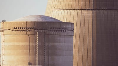 Vue rapprochée des bâtiments du réacteur nucléaire baignés dans une lumière dorée, mettant en valeur l'architecture industrielle.