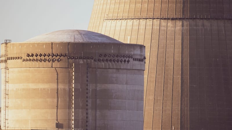 Vue rapprochée des bâtiments du réacteur nucléaire baignés dans une lumière dorée, mettant en valeur l'architecture industrielle.