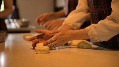 Gros plan des mains formant de la pâte dans une cuisine chaleureuse, parfait pour les amateurs de pâtisserie.