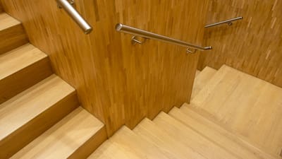 Escalier en bois contemporain avec des rampes en métal élégantes dans un cadre intérieur.