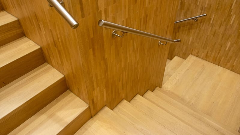 Escalier en bois contemporain avec des rampes en métal élégantes dans un cadre intérieur.