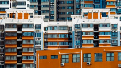 Vue en gros plan de façades d'appartements vibrants avec des unités de climatisation dans un cadre urbain.