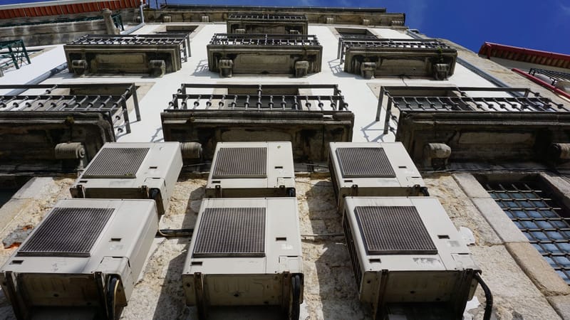 Une vue en hauteur d'une façade de bâtiment avec des climatiseurs et des balcons à Porto.