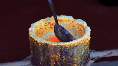 Gros plan sur de l'or en fusion dans un creuset, illustrant le processus de fusion dans une fonderie de Bangkok.