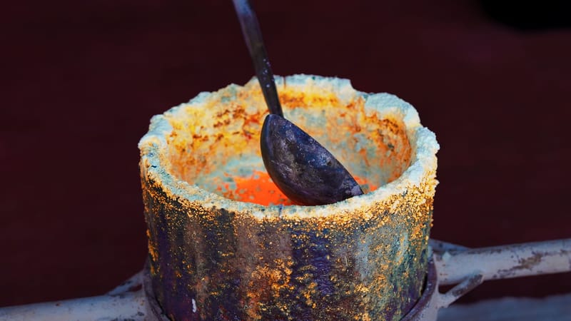 Gros plan sur de l'or en fusion dans un creuset, illustrant le processus de fusion dans une fonderie de Bangkok.
