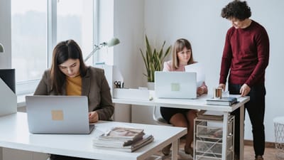 Groupe de collègues travaillant ensemble dans un espace de bureau moderne et lumineux avec des ordinateurs portables.