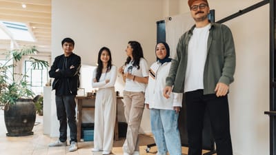 Groupe divers de jeunes professionnels souriants dans un environnement de bureau moderne, mettant en avant le travail d’équipe et l'inclusivité.