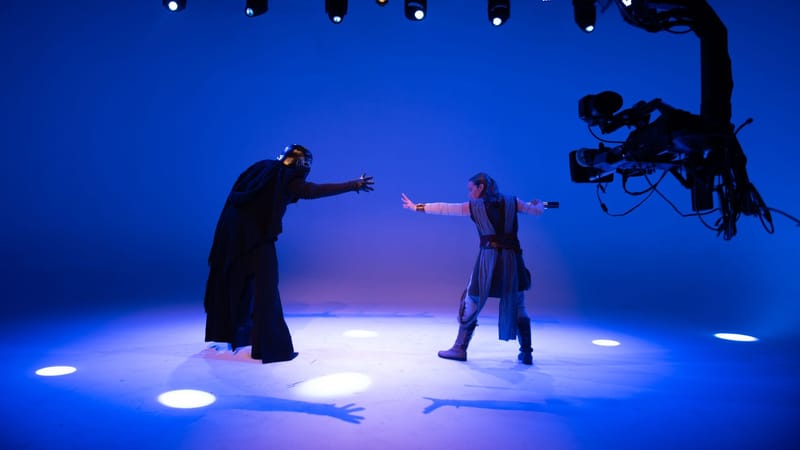 Des acteurs jouent une scène de science-fiction sous des lumières de studio brillantes avec une technologie de tournage avancée.