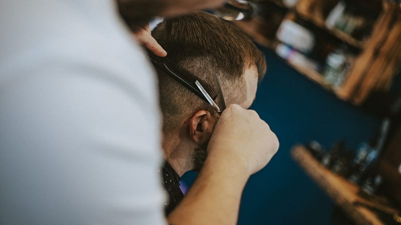 Scène de coupe de cheveux dans un salon de coiffure polonais capturant l'art du toilettage et du style modernes.