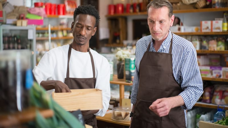 Deux employés masculins organisant les produits dans une épicerie accueillante.