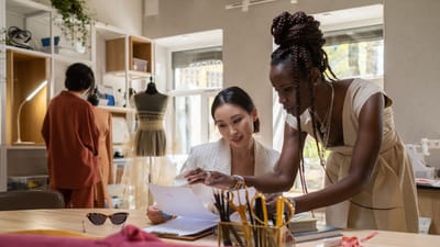 Des professionnels de la mode collaborant dans un studio de design moderne, révisant des créations.