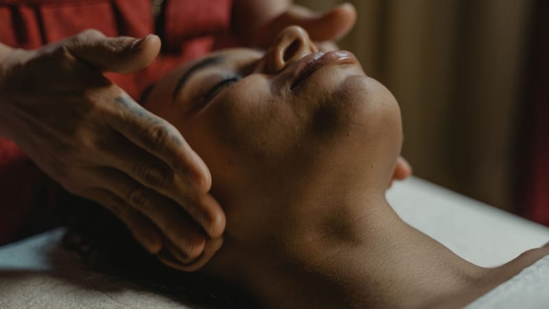 Gros plan sur une femme recevant un massage du visage relaxant favorisant le bien-être.
