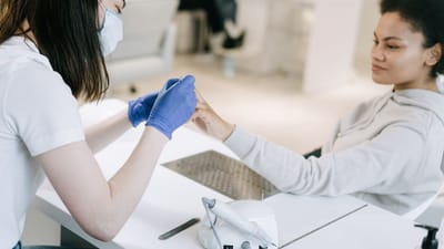 Une femme recevant une manucure dans un salon de manucure, mettant l'accent sur le soin de soi et la relaxation.