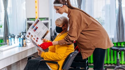 Coiffeur aidant un client à choisir la couleur de cheveux dans un salon moderne.