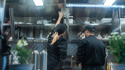 Deux chefs travaillant ensemble dans une cuisine professionnelle, préparant de la nourriture.