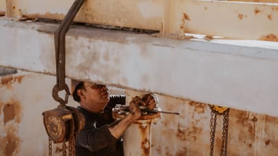 Un ouvrier libyen répare des machines industrielles en plein air par une journée ensoleillée.