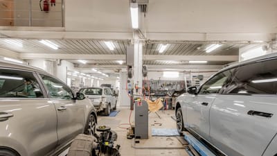 Intérieur d'un garage automobile avec des voitures en cours de maintenance et de service.