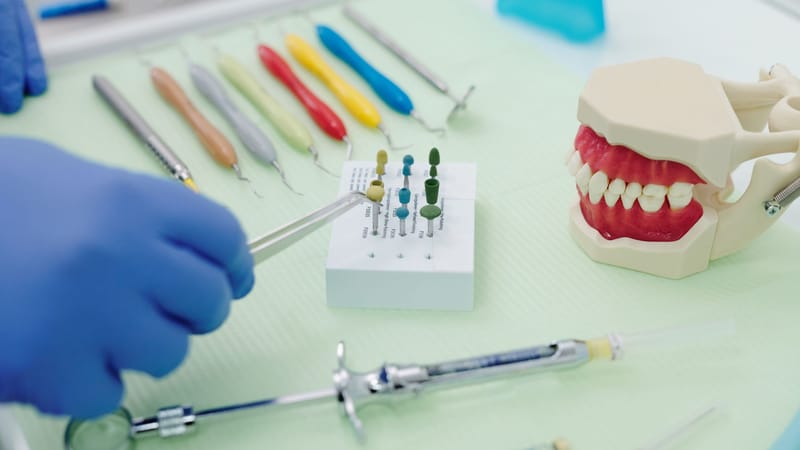 Un ensemble d'instruments dentaires avec une mâchoire en modèle sur une table stérile, mettant en valeur des outils dentaires professionnels.
