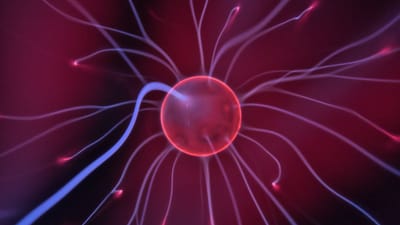 Gros plan d'une boule plasma lumineuse avec des courants électriques colorés s'étendant vers l'extérieur.