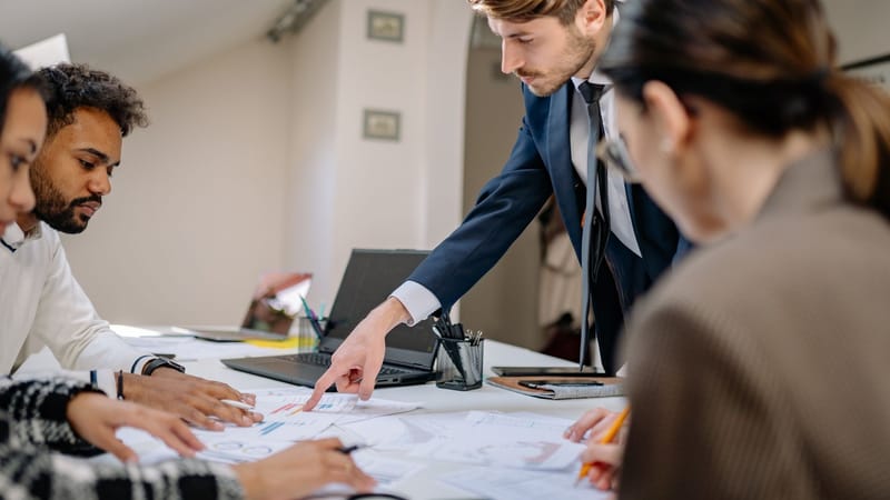 Une équipe diversifiée engagée dans une réunion d'affaires, favorisant la collaboration et le travail d'équipe dans un environnement de bureau.