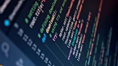 Gros plan d'un écran d'ordinateur affichant du code de programmation coloré avec un flou d'arrière-plan.