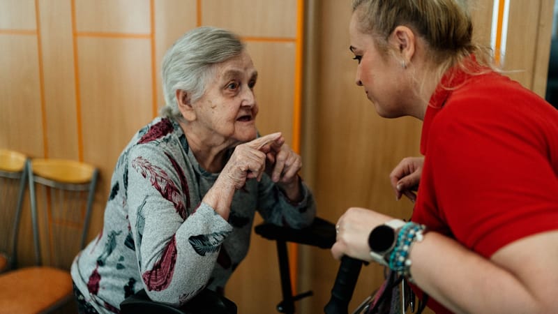 Femme âgée et assistante en conversation dans une pièce à Karviná, République tchèque.