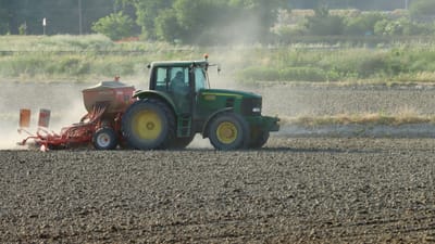 Un tracteur labourant un champ pendant la journée à Novara, en Italie, mettant en avant des techniques agricoles modernes.