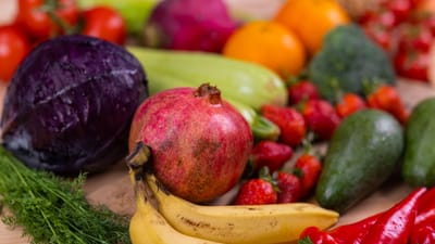 Une variété de fruits et légumes frais joliment disposés sur une table en bois, mettant en valeur la nutrition naturelle.