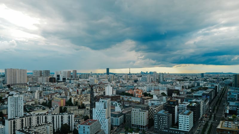 Vue panoramique aérienne d'une ligne d'horizon moderne sous des nuages dramatiques au crépuscule.