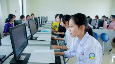 Étudiants engagés dans l'étude dans un laboratoire informatique, concentrés sur la technologie et le travail d'équipe.