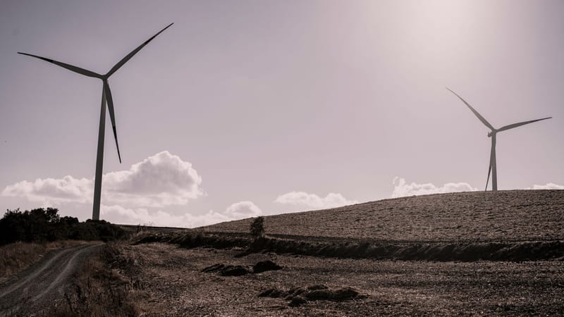 Éoliennes sous un ciel ensoleillé dans un paysage rural, capturant l'énergie renouvelable de la nature.