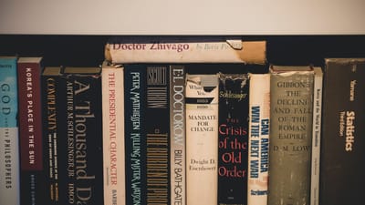 Gros plan de littérature classique sur une étagère en bois, offrant une ambiance vintage et éducative.