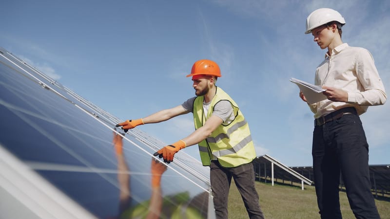 Deux ingénieurs examinent des panneaux solaires, assurant une installation et un fonctionnement appropriés.